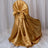 Gold satin chair cover with bow detail.