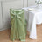 Green satin chair cover with bow detail for elegant dining setups.