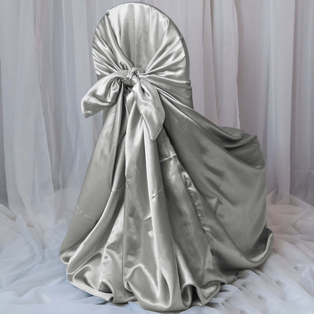 Silver satin chair cover with bow detail, elegantly draped.