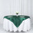 Elegant round green satin tablecloth draped on a white table with wine glasses and flowers.