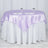Purple satin tablecloth draped over a round table with white skirt.