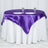 Round table with a purple satin tablecloth and two plates