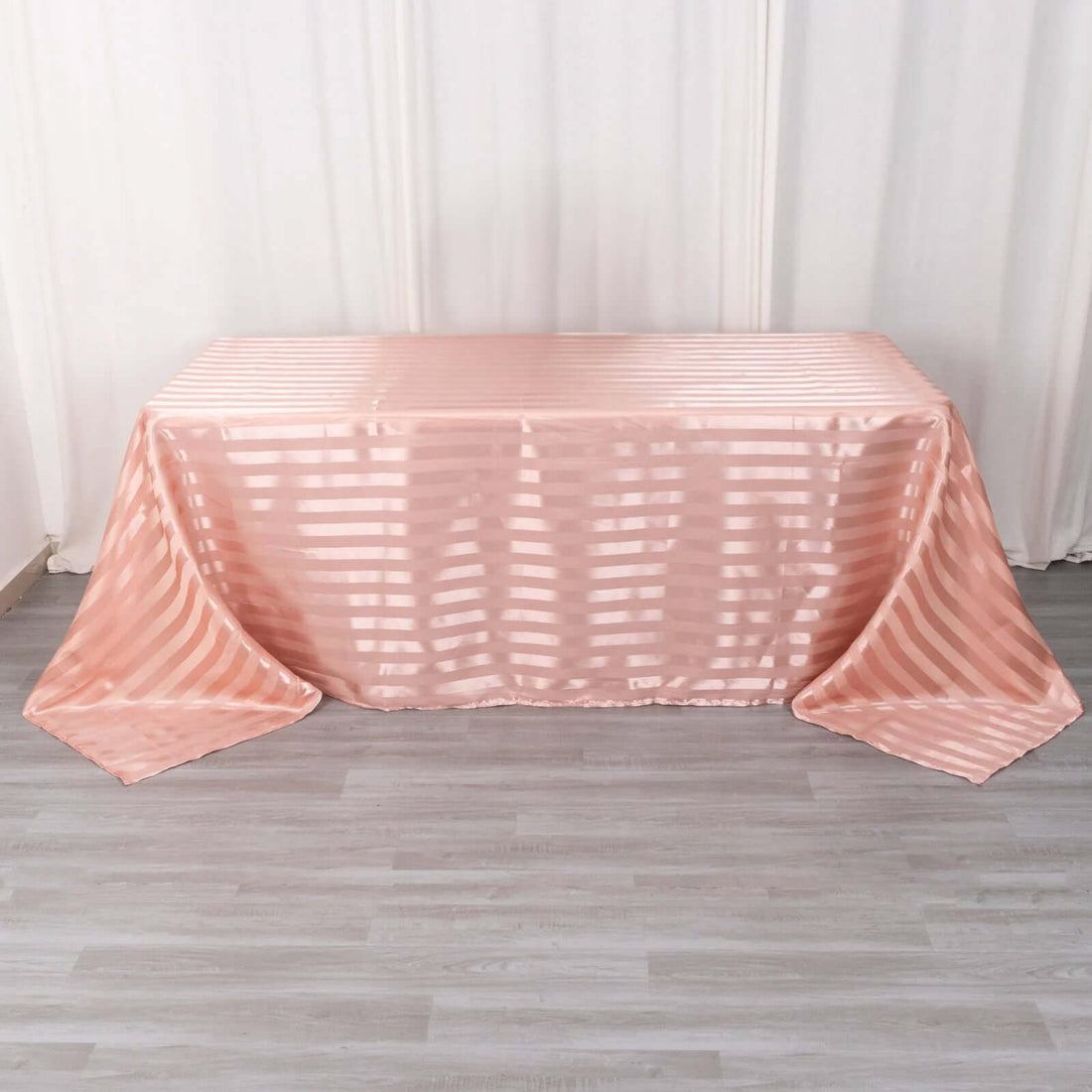 Pink striped tablecloth draped over a table in a studio setting.