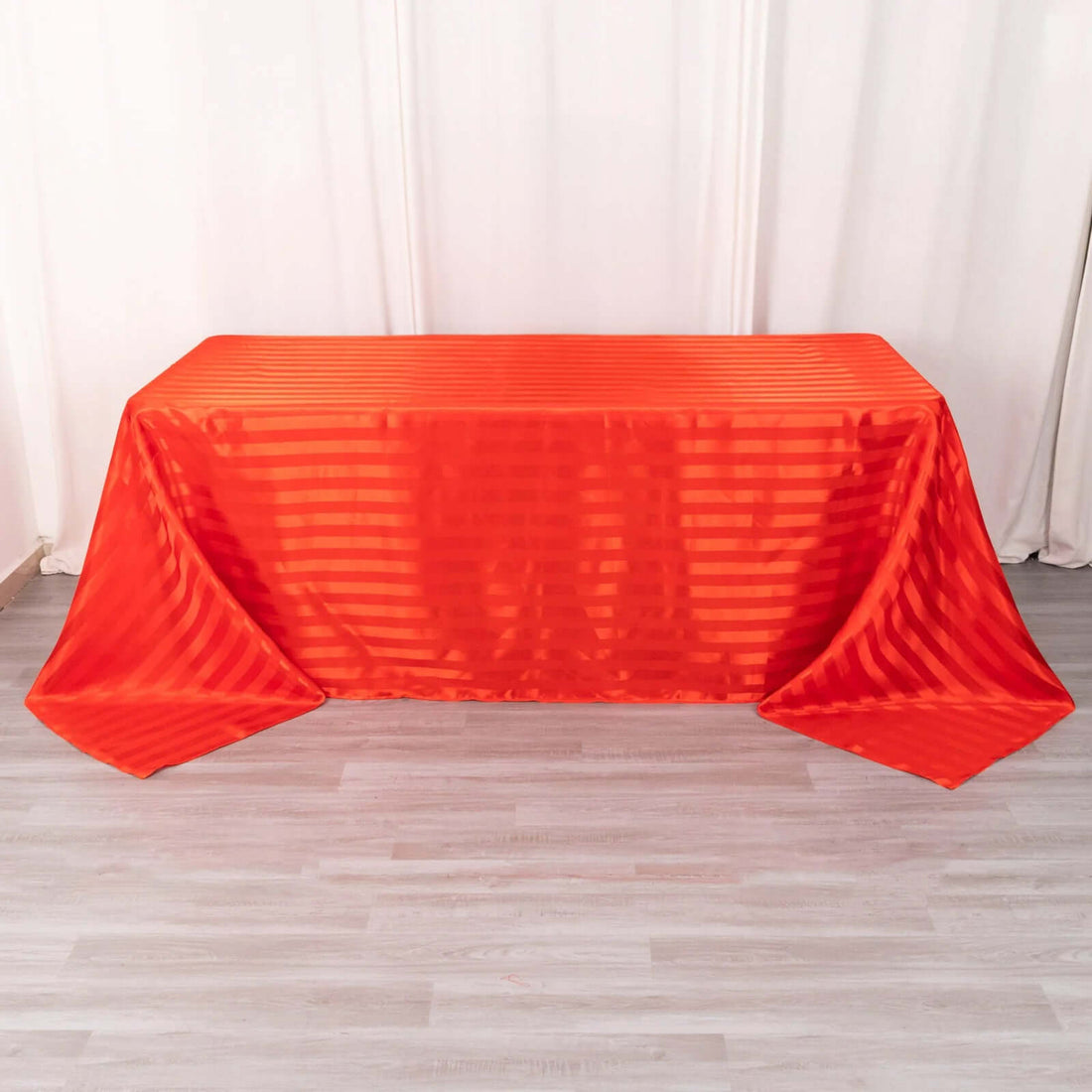 Red striped tablecloth draped over a table in a studio setting.