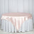 Pink satin tablecloth draped over a round table with a white skirt.
