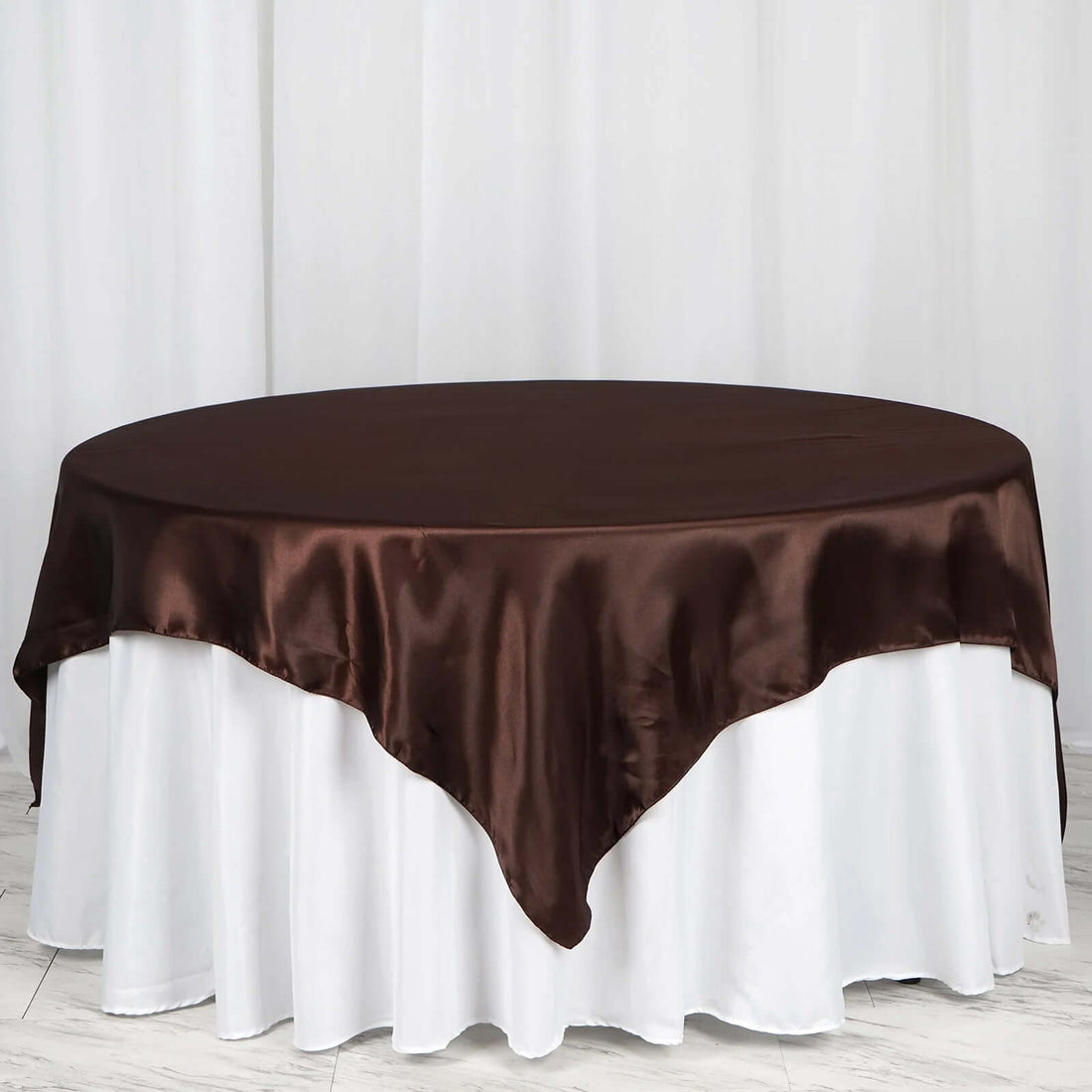 Brown satin tablecloth draped over a white table.