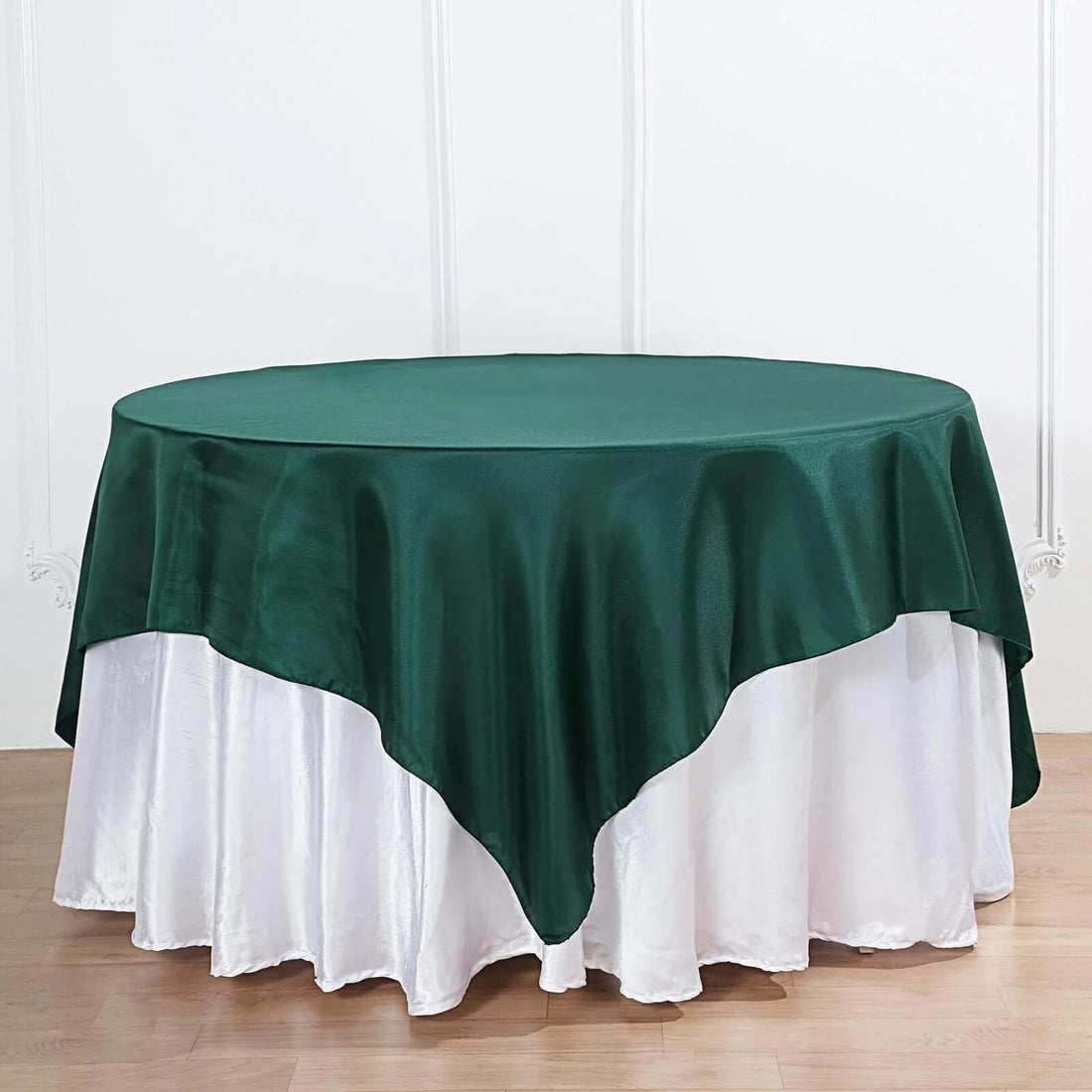 Green round tablecloth draped elegantly over a white table.