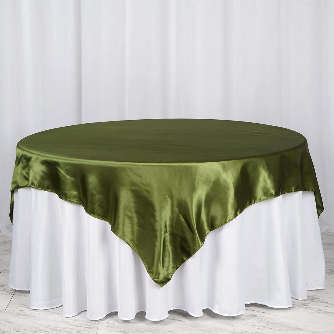 Green satin tablecloth draped over a white table skirt.