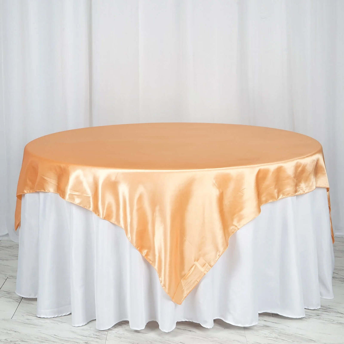 Orange satin tablecloth draped elegantly over a round table
