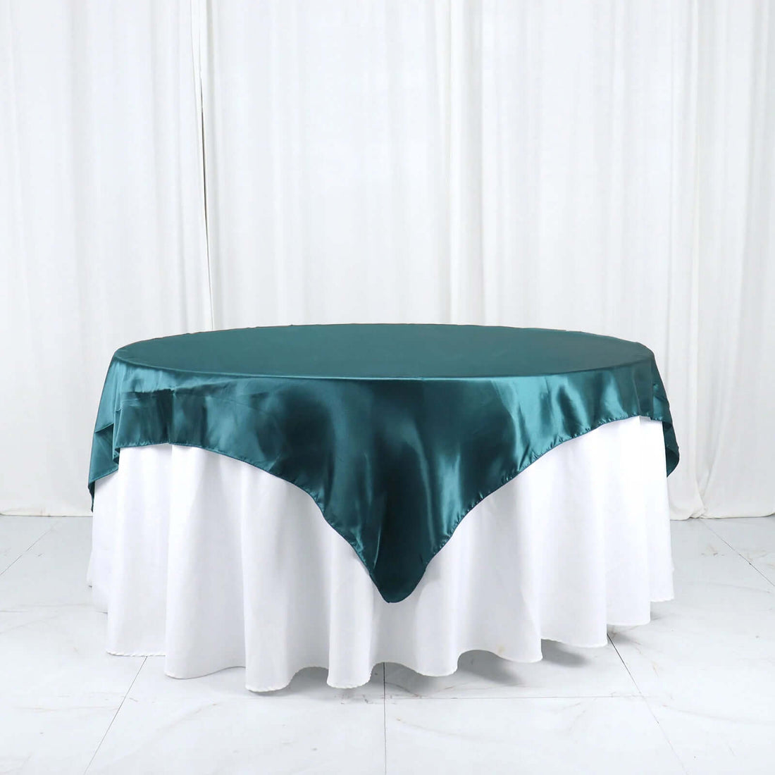 Teal satin tablecloth on a white table