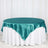 Teal satin tablecloth draped elegantly over a round table.