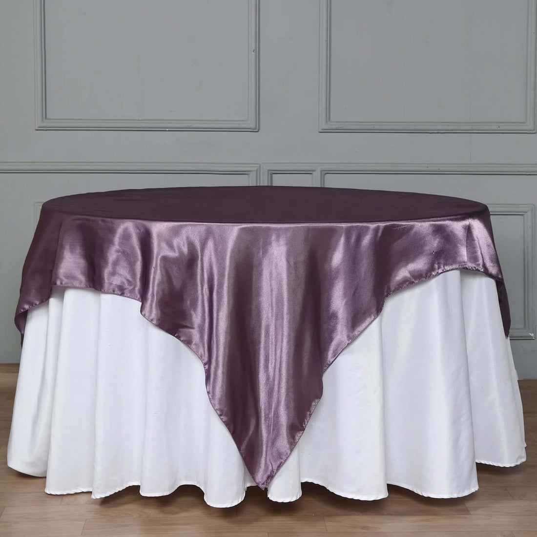 Elegant purple satin table overlay on a round white table.