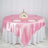 Elegant round table set with pink satin tablecloth and floral centerpiece.