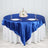 Round blue satin tablecloth draped over a white table with elegant place settings.