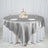 Elegant silver tablecloth draped over a round table with decorative centerpiece.