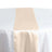 Peach satin table runner on a light purple table with folded napkins #whtbkgd