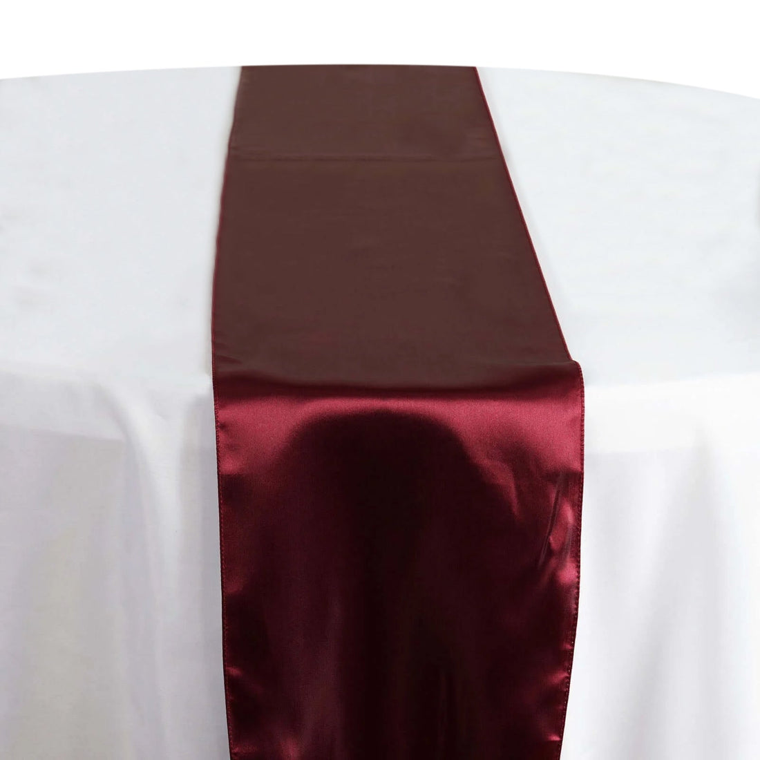 Burgundy satin table runner on a white table #whtbkgd