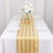 Elegant gold striped table runner on a beautifully set dining table with flowers.