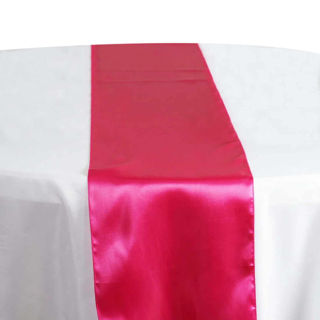 Hot pink satin table runner on a white table. #whtbkgd