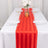 Red striped table runner on a white table with elegant tableware and floral centerpiece.