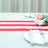 Red and white striped table runner with floral centerpiece and plates