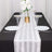 Elegant table setting with white plates, glasses, and a floral centerpiece.