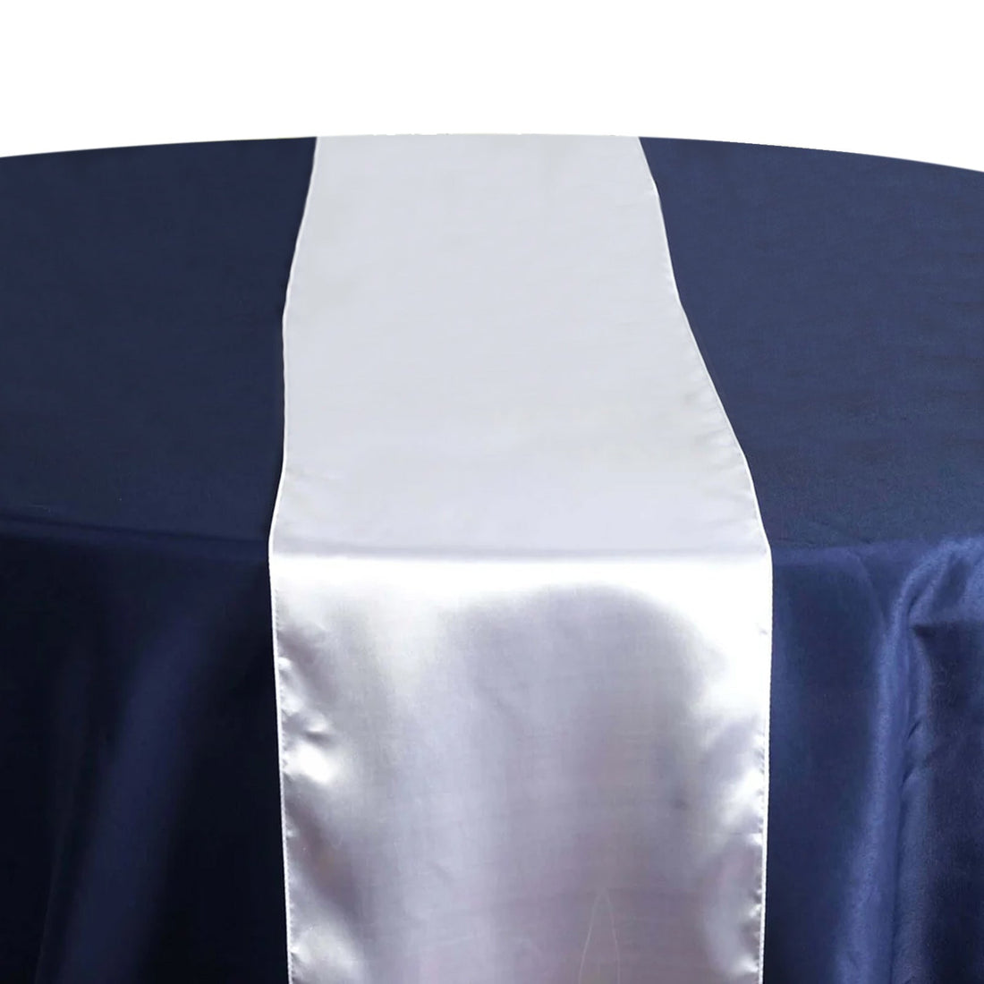 White satin table runner on a dark blue tablecloth #whtbkgd