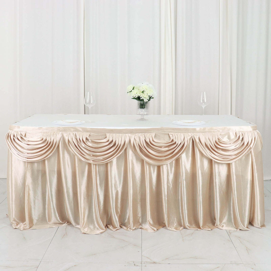 Elegant champagne table skirt with draped design for events and weddings.