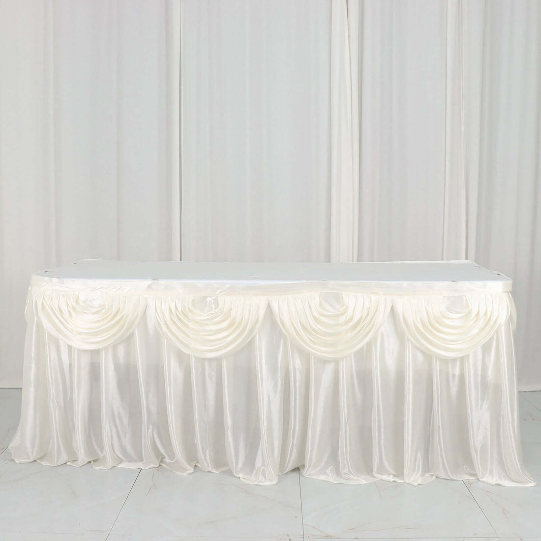 White satin table skirt with elegant draping and pleats.