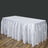 White table with a flowing satin skirt on a wooden floor.