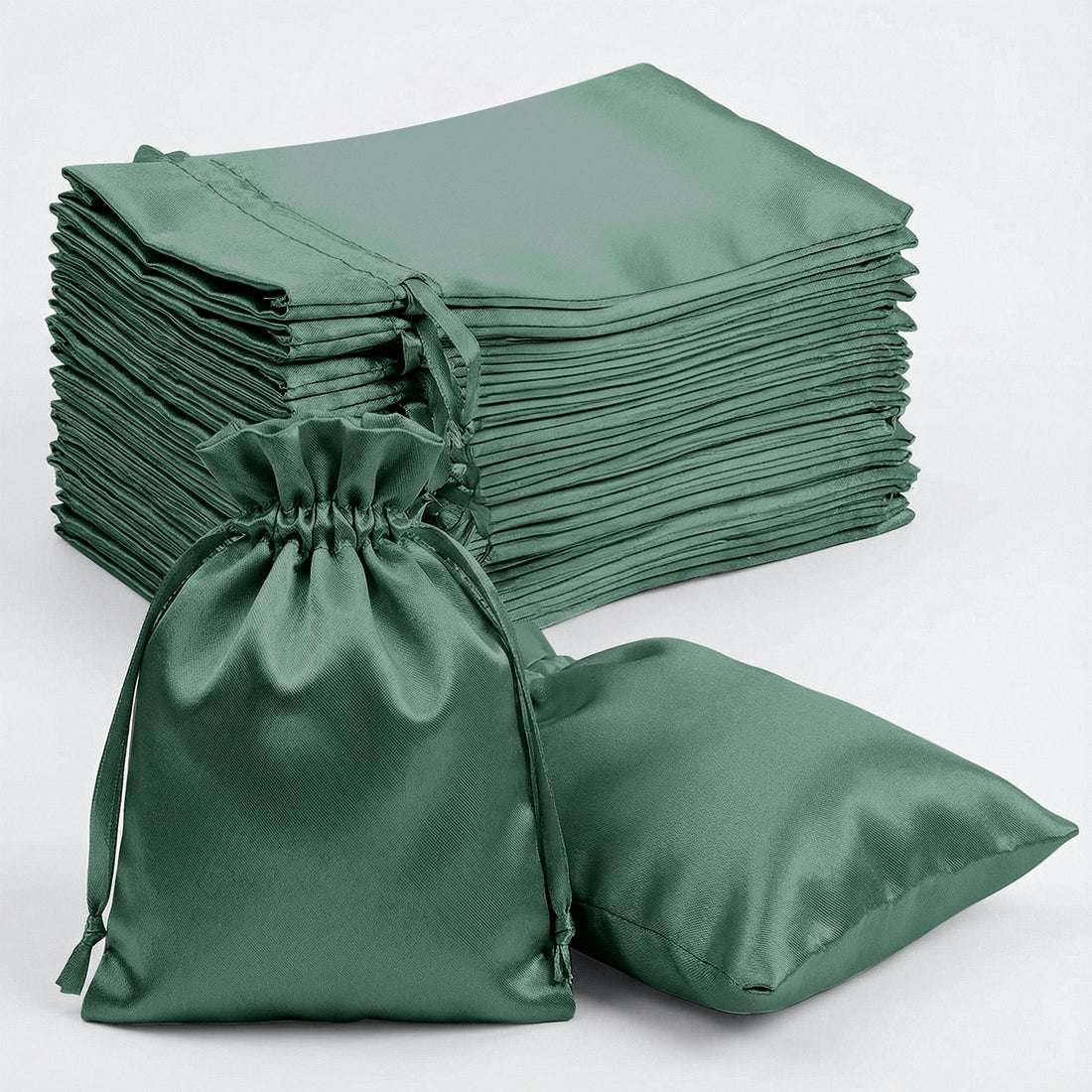 Green satin drawstring bags stacked and one on its side.