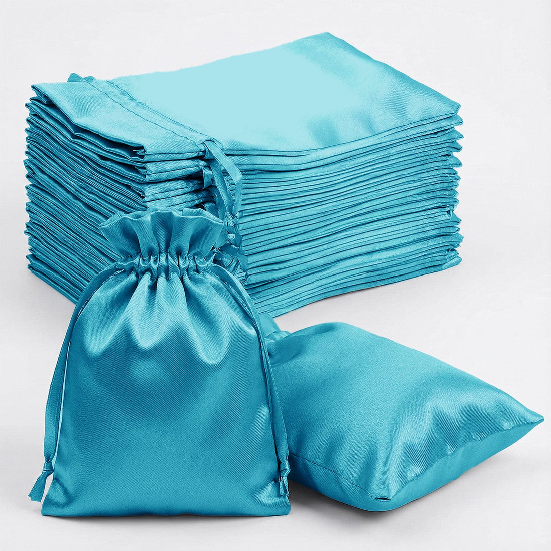 Set of turquoise satin drawstring bags and cushions