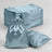 Blue satin bags stacked with one bag and pillow on a plain background