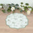 Floral patterned table mat on a wooden surface with decor elements.