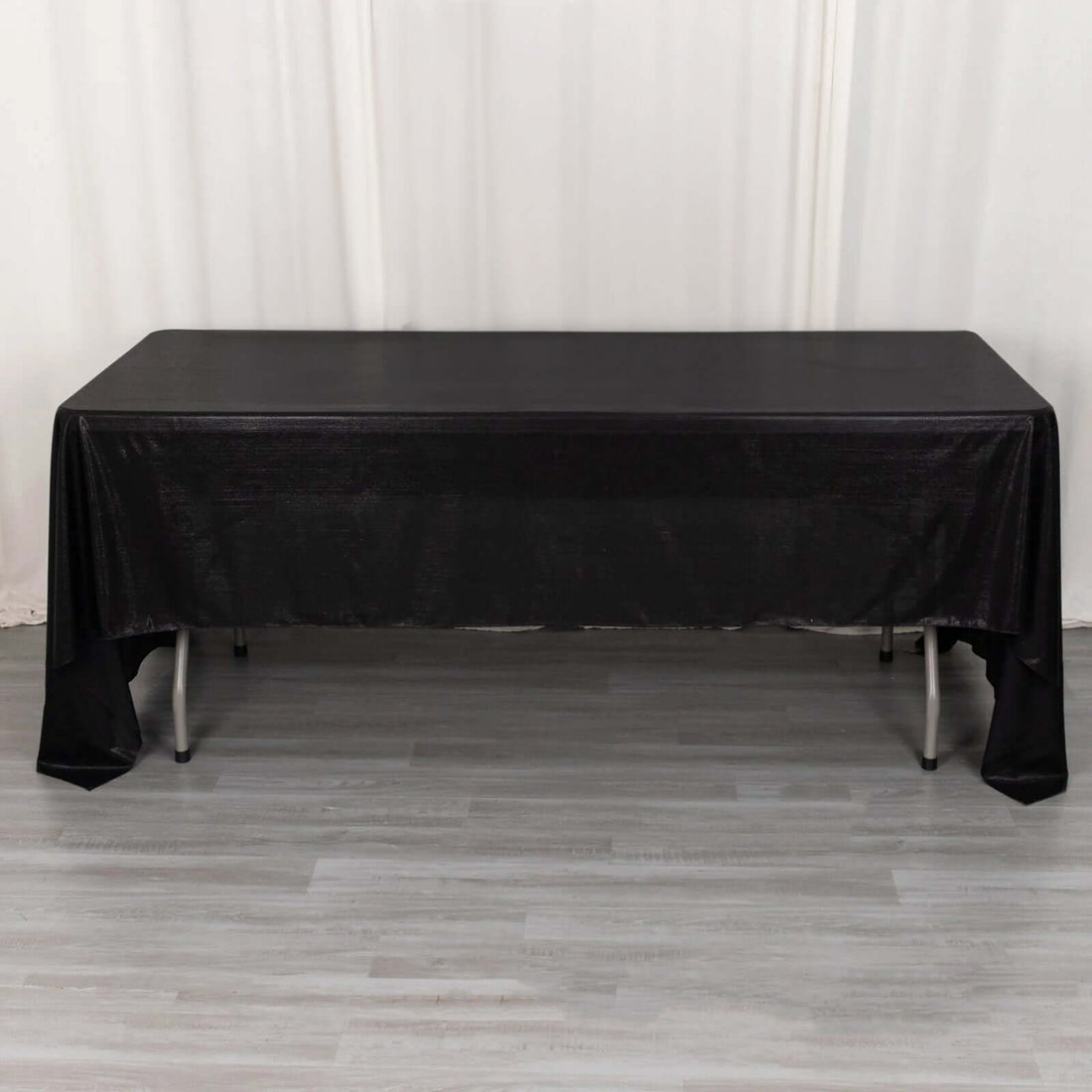 Black tablecloth draped over a rectangular table in a studio setting.