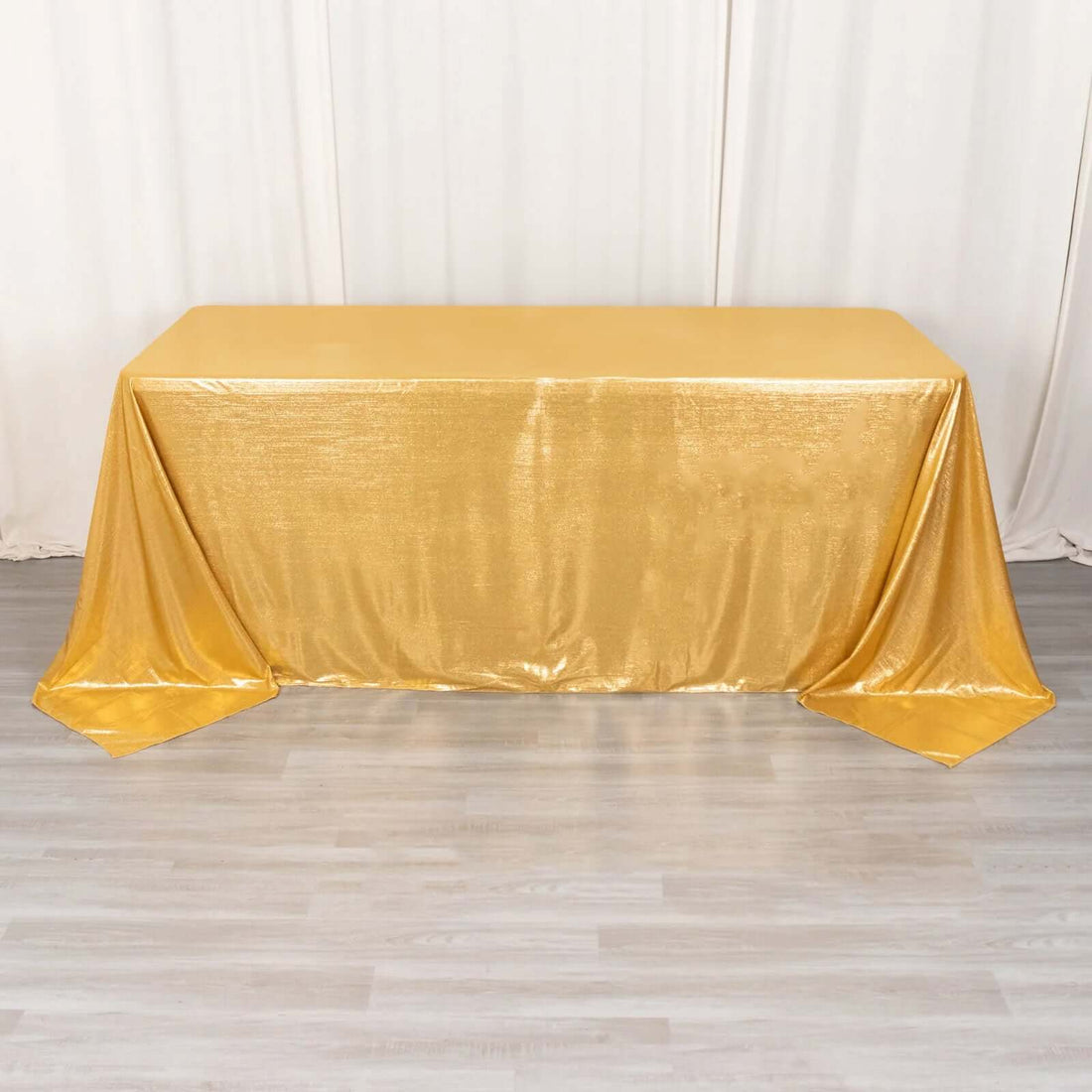 Gold tablecloth with shimmering texture on a plain backdrop.