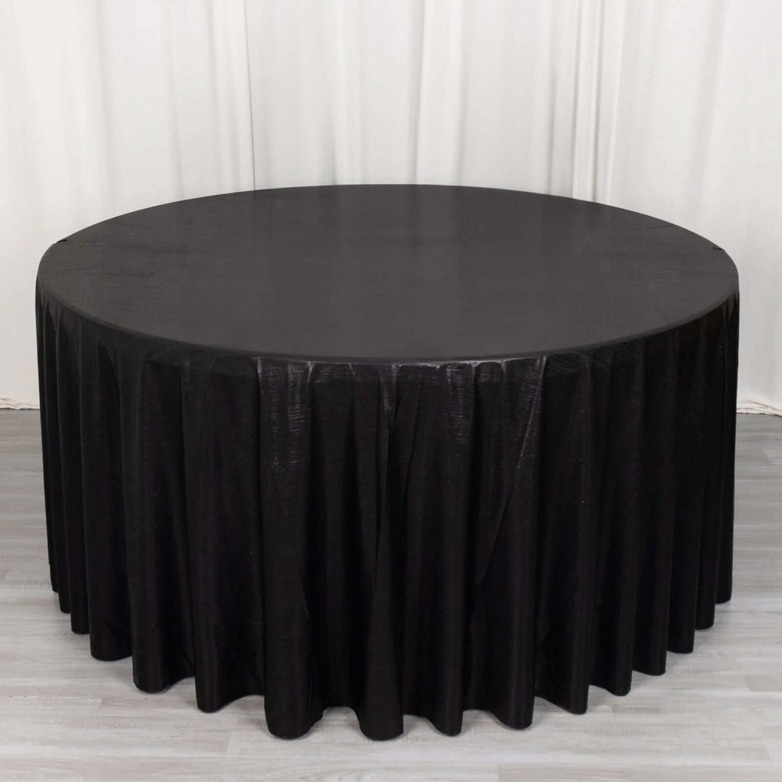 Black round tablecloth with pleated design for events and dining.