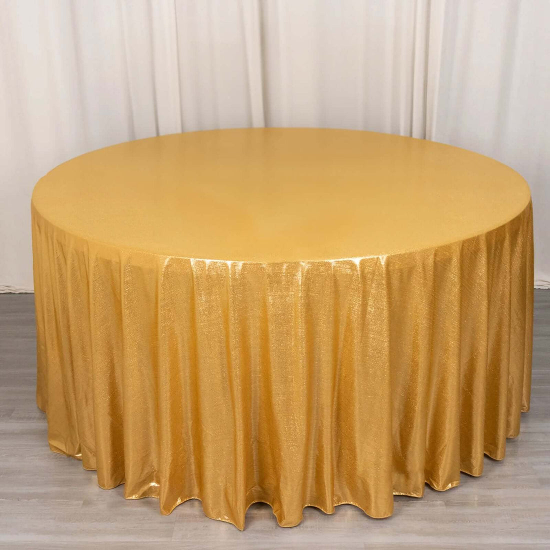 Gold sequin tablecloth draping over a round table.