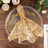 Gold sequined napkin wrapped with a decorative ring on a clear plate.