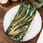 Green and gold sequin table napkin on a decorative plate.