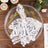Elegant white lace napkin with silver ring on decorative plate.