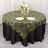 Elegant green and gold wave patterned tablecloth on a round table with floral centerpiece.