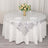 Round table with elegant silver patterned tablecloth and floral centerpiece.