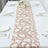 Elegant floral table runner on a dining table set for a meal.