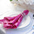 Sparkling pink sequin napkin elegantly arranged on a dining plate.