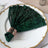 Green sequin napkin elegantly folded on a decorative plate.
