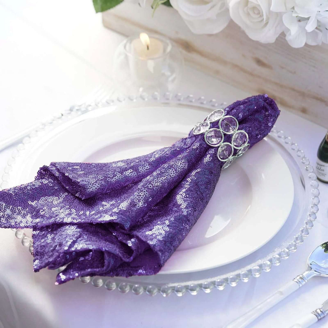 Purple sequin napkin elegantly styled on a white plate with crystal rim.