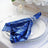 Blue sequin napkin elegantly arranged on a dinner plate with decorative holder.