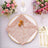 Rose gold sequin table napkin with decorative flower on an elegant dinner plate.