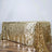 Gold sequin tablecloth draped elegantly on a wooden table.